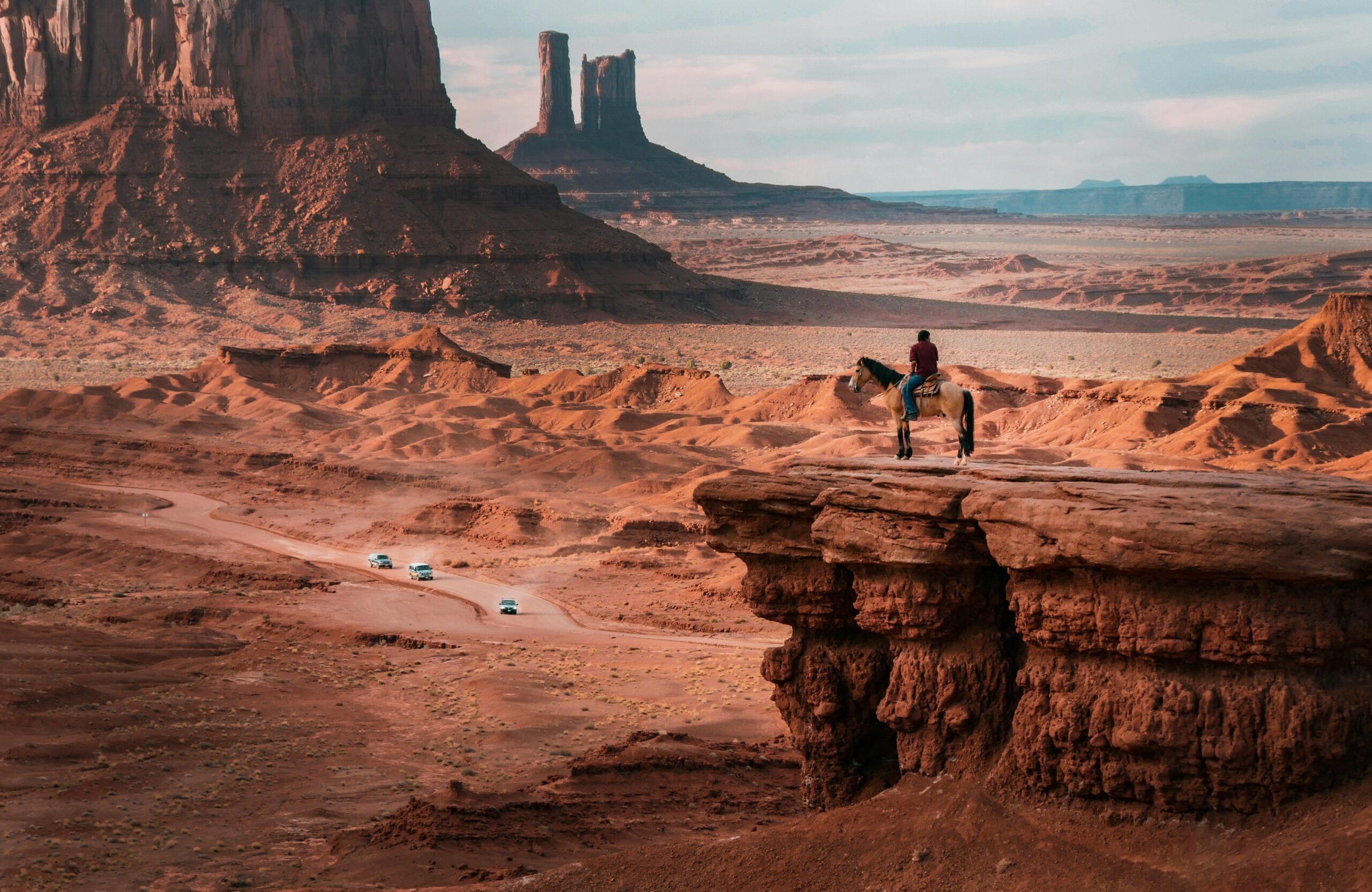 person riding on horse near cliff